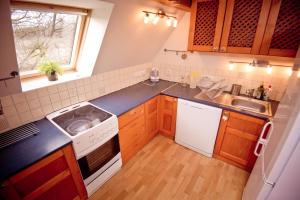 a small kitchen with a sink and a stove at Penzion PIŠLIKDUM in Stará Červená Voda