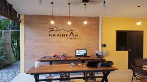a room with a wooden table and a brick wall at Narinfah Resort in Kaeng Krachan