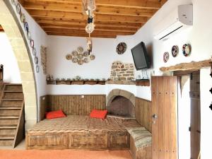 アルハンゲロスにあるAnemos Traditional Villaの暖炉付きの客室の小さなベッド1台分です。