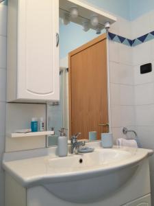 ein Badezimmer mit einem weißen Waschbecken und einem Spiegel in der Unterkunft Casa Ducati in Riva del Garda