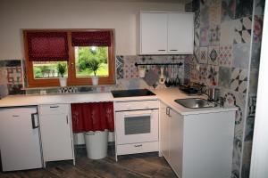 a kitchen with white cabinets and a sink at Apartma Obrh in Smarjeske Toplice