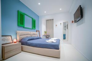 a bedroom with a bed and a tv on the wall at Mareè Seafront B&B - Sea View King Room in Molfetta