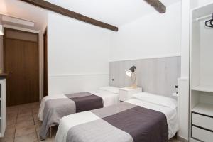 two beds in a room with white walls at B&B Il Viottolo in Noci