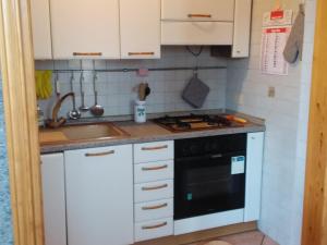 La cuisine est équipée de placards blancs, d'une cuisinière et d'un évier. dans l'établissement Appartamento vista mare, 100mt dall'Ospedale Pediatrico, a 200mt dal mare, 1h da Roma Termini, à Santa Marinella 44 autres photos