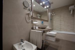a bathroom with a sink, toilet and bathtub at Hotel Don Paco in Málaga