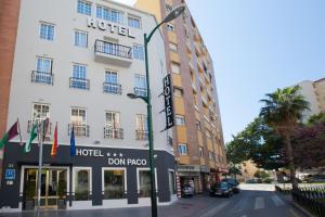 um hotel numa rua da cidade com uma luz de rua em Hotel Don Paco em Málaga
