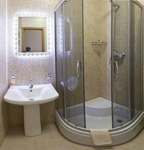 a bathroom with a glass shower and a sink at Kyiv apartment on Starokyivskaya lane 5 in Kyiv