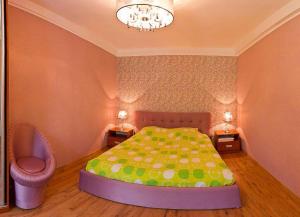 a bedroom with a bed and a chair and a chandelier at Kyiv apartment on Starokyivskaya lane 5 in Kyiv