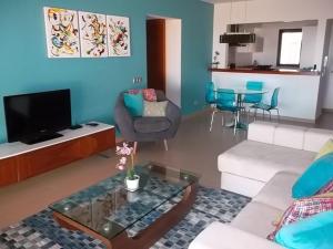 a living room with a couch and a table at Mar da Luz, Algarve in Luz