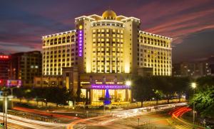 a large white building with a purple sign on it at Shenzhen Dayhello international Hotel (Baoan) in Bao'an