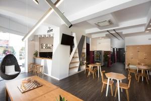 ein Zimmer mit Tischen und Stühlen und einer Treppe in der Unterkunft Cocoon City Hostel in Chania