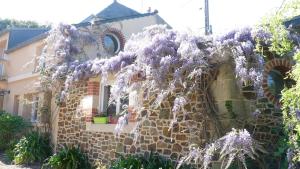 uma casa coberta de glicínias em frente a uma casa em Gite de la Renaissance, Binic , Bretagne em Binic