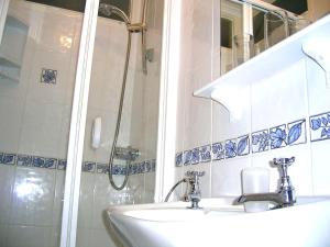 a bathroom with two sinks and a shower at Harrington Guest House in Newquay