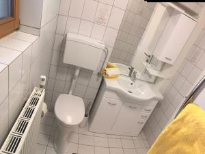 ein weißes Badezimmer mit Toilette und Waschbecken in der Unterkunft Ferienwohnung Beate Hassler in Berg im Drautal