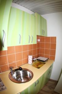 a bathroom with a sink and orange and green cabinets at Master Apartments in Belgrade