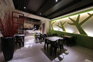 um restaurante com mesas e cadeiras e uma parede verde em Early Summer em Luodong