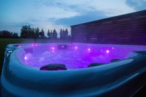 a jacuzzi tub with purple lights in front of a building at Oduo in Sart-lez-Spa