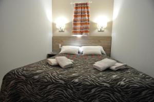 1 cama grande en una habitación con 2 almohadas en Aparthotel Safari en Calella