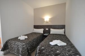 two beds in a small room with towels on them at Aparthotel Safari in Calella