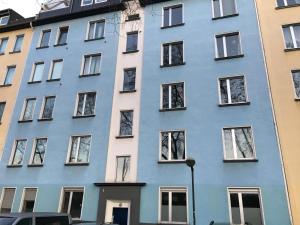 un edificio azul con ventanas en una calle en AVI City Apartments GoodHouse, en Düsseldorf