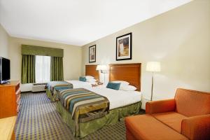 a hotel room with two beds and a couch at Wingate by Wyndham Atlanta Fairburn in Fairburn +24 photos
