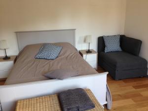 um quarto com uma cama grande e uma cadeira em Un petit nid a Honfleur em Honfleur