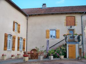 Casa con persianas de madera y balcón. en Gite De La Tour De Rouilleres, en Ambierle
