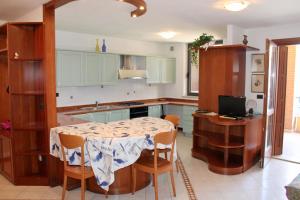 a kitchen with a table with chairs and a kitchen with blue cabinets at Isola del Sole in Grado