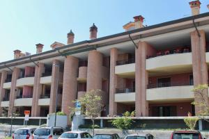 an apartment building with cars parked in front of it at Isola del Sole in Grado