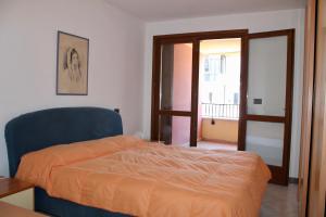 a bedroom with a bed with an orange comforter at Isola del Sole in Grado