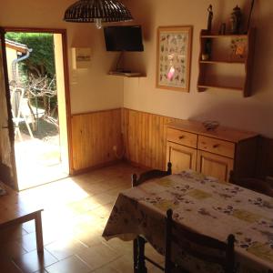 a dining room with a table and a kitchen at Les Petits Prés in Vitrac