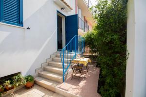 un piccolo balcone con tavolo e scale in una casa di Noto Sole di Sicilia a Noto Marina