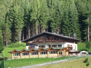 una grande casa su una collina vicino a una foresta di Albergo Krissin a Santo Stefano di Cadore