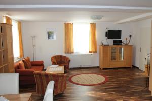 a living room with a couch and a tv at Familienappartement Ötscherbär in Lackenhof