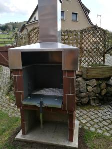 a large barbecue grill sitting in a yard at Ferienhaus am Radweg in Brotterode-Trusetal