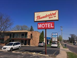 un cartel de motel con coches estacionados frente a un edificio en Thunderbird Motor Inn, en Baraboo