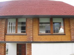 un hombre mirando por la ventana de una casa en Holiday Home Slavica, en Kupres