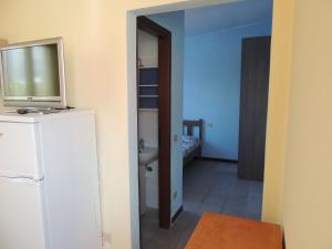 a bathroom with a television on top of a refrigerator at Appartamenti Camping Rivamare in Albenga