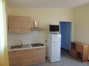 una pequeña cocina con nevera y microondas en Appartamenti Camping Rivamare, en Albenga