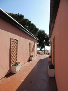 Une allée avec des plantes en pot sur le côté d'un bâtiment dans l'établissement Appartamenti Camping Rivamare, à Albenga