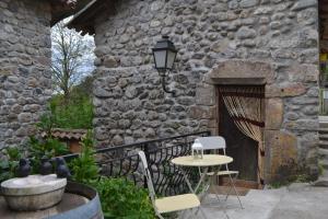 a patio with a table and chairs and a stone building at Maison Sous Le Pont in Meyras +33 photos
