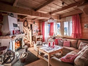ein Wohnzimmer mit einem Sofa und einem Kamin in der Unterkunft GORSKA OSADA Lovely Chalets Zakopane in Poronin