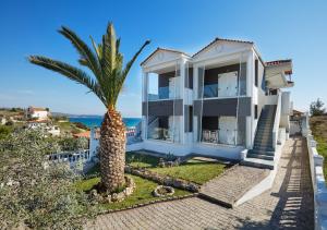 a house with a palm tree in front of it at Villa Fylaktos in Limenaria