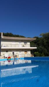 a large swimming pool with a building in the background at La Sirenetta Residence in Sivota
