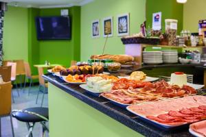 a buffet with meats and other food on a counter at Pontus Veteris in Sanxenxo