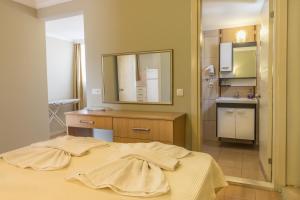a bedroom with a bed and a mirror and a kitchen at Hotel Dost in Marmaris +88 photos