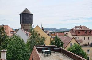 a view of a city with a table on a roof at Haus Buchheim - Pension am Schloss in Bautzen