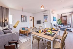 ein Wohnzimmer mit Tisch und Stühlen und einer Couch in der Unterkunft Sweett - Pedrera Department 24 in Barcelona