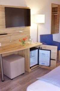 Zimmer mit Schreibtisch und TV in der Unterkunft Stichwehs Hotel am Bahnhof in Elze