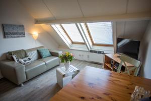 a living room with a couch and a table at Appartementenhotel Tjermelân Terschelling in Oosterend